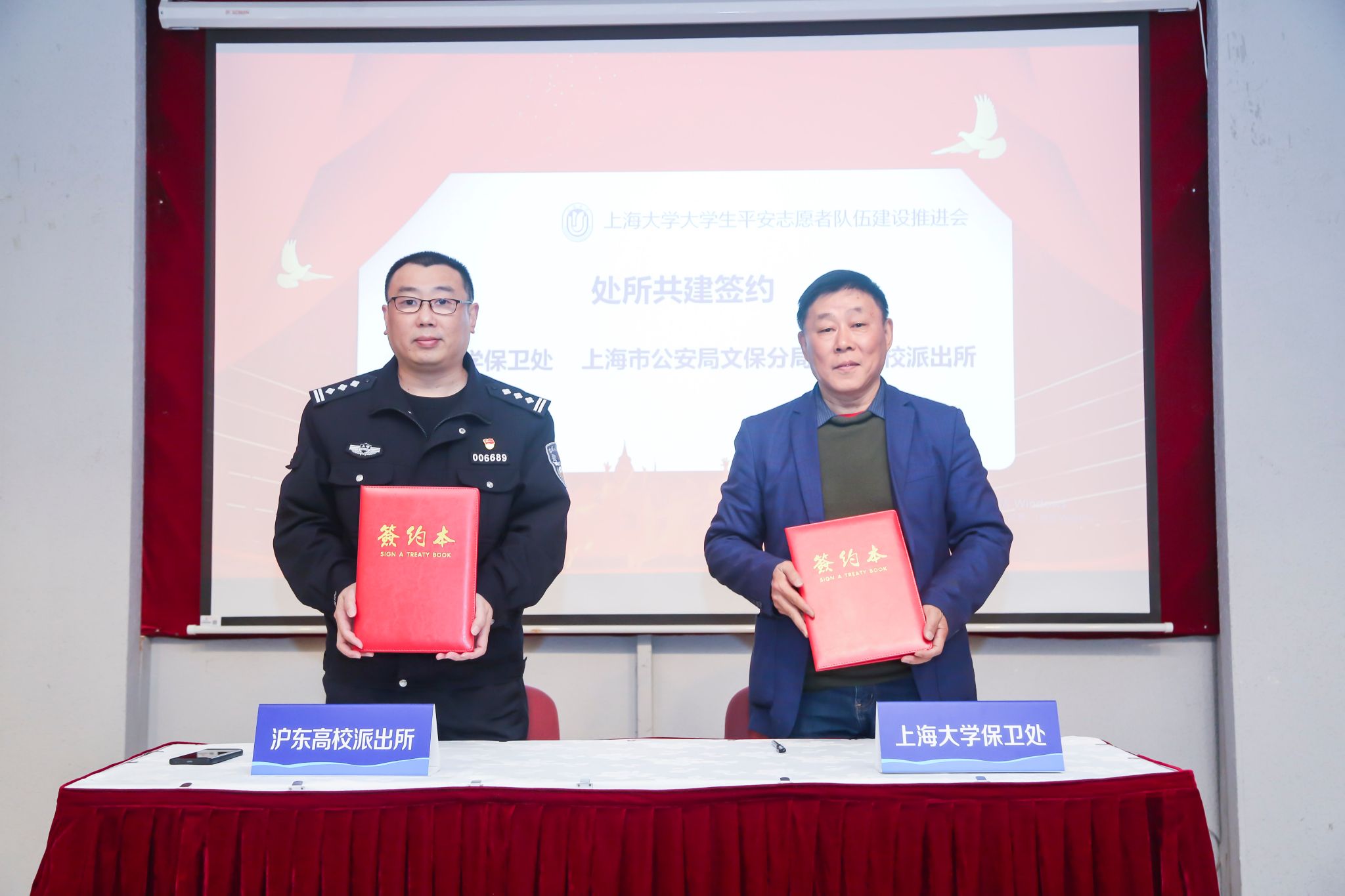 上海大学保卫处处长沈龙骥与上海市公安局文保分局沪东高校派出所所长胡军代表双方签约.jpg
