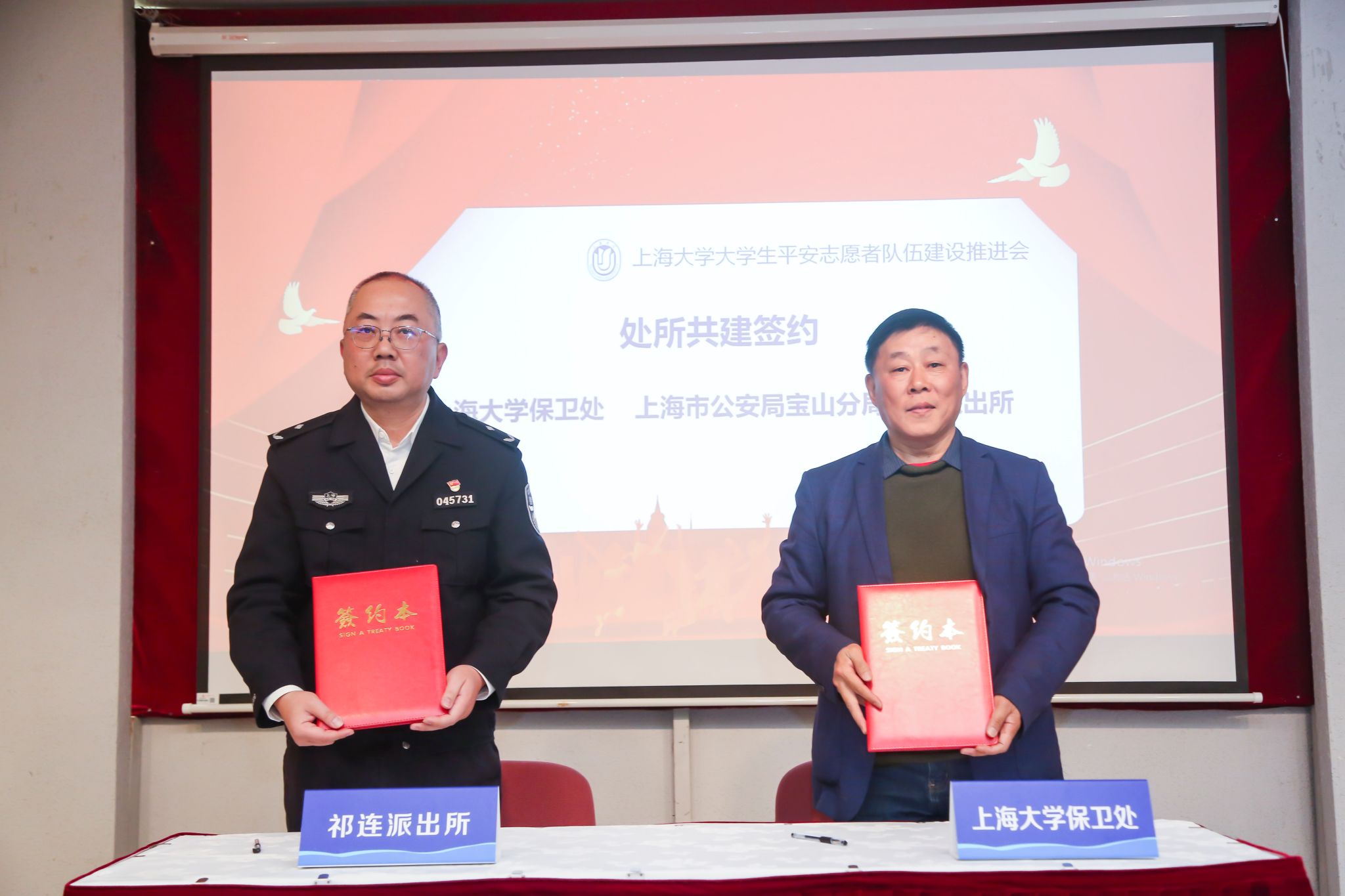 上海大学保卫处处长沈龙骥与上海市公安局宝山分局祁连派出所所长谢国卫代表双方签约.jpg